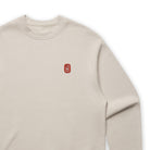 Beige sweatshirt with a red logo on a white background